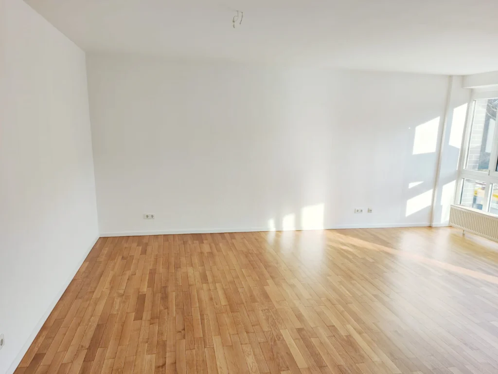 Fertiggestellter Raum mit großer Fensterfront mit weißen Wänden und einem Holzboden