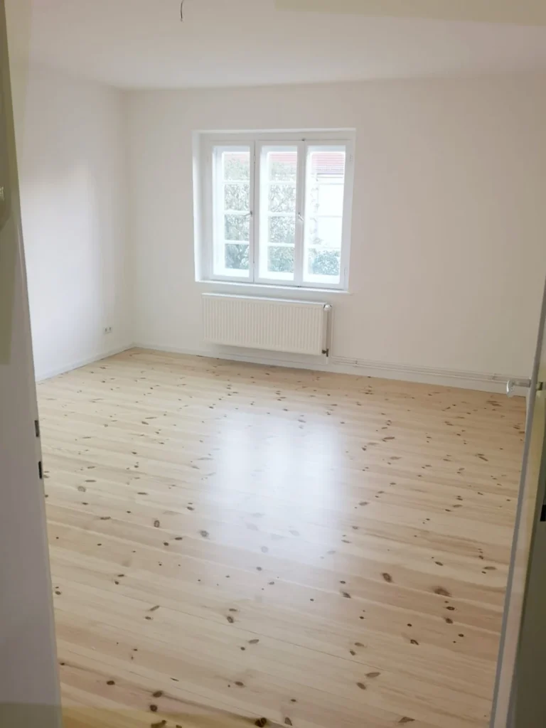 Neu verlegter Holzboden in einem großen, leeren Raum